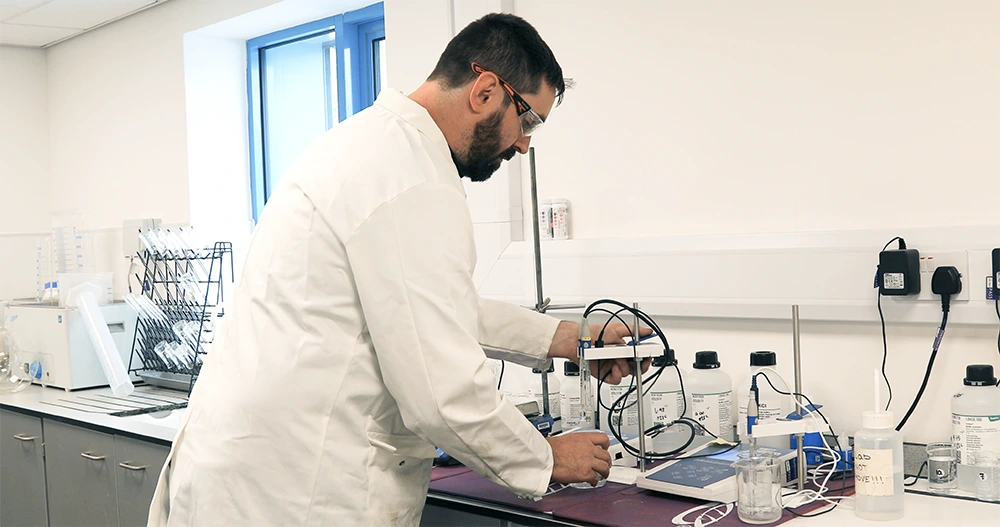 Water treatment technician testing chemical dosing and water quality in a laboratory